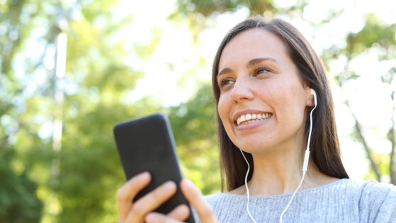 A woman listening to something on her smartphone with headphones